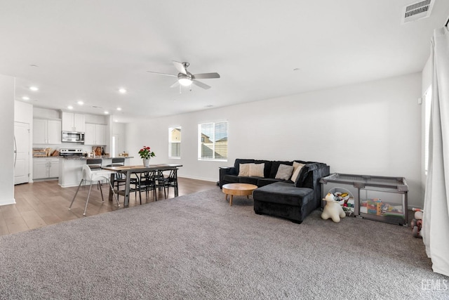 living room with light wood finished floors, visible vents, recessed lighting, and a ceiling fan