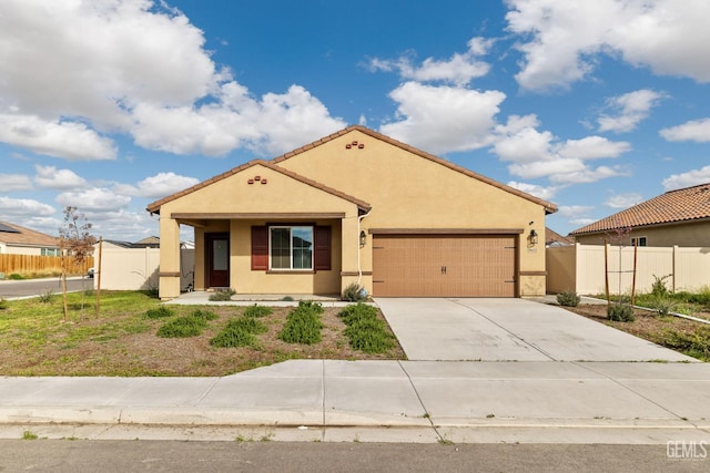 mediterranean / spanish-style house with concrete driveway, fence, a garage, and stucco siding