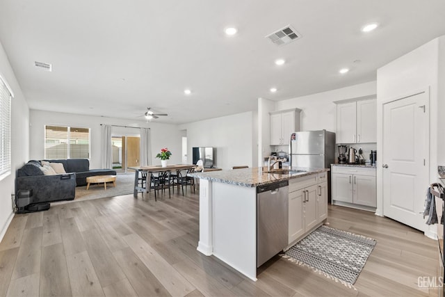 kitchen featuring visible vents, light wood-style flooring, stainless steel appliances, and open floor plan