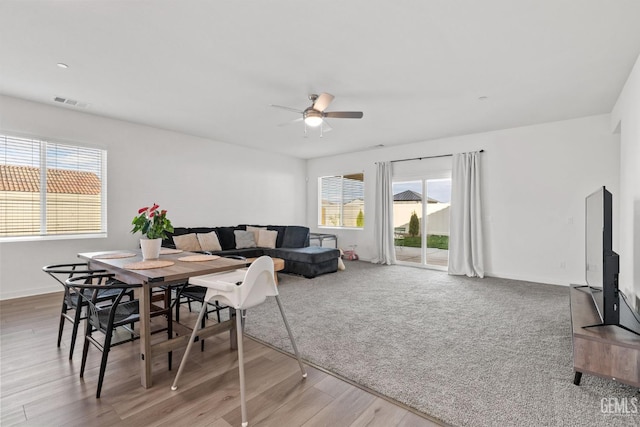 dining area with wood finished floors, a ceiling fan, visible vents, and baseboards