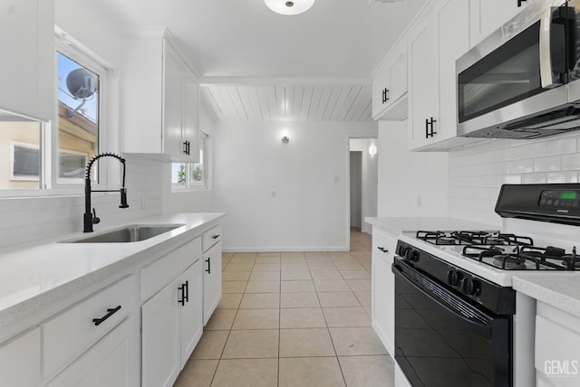 2804 Haley St, Bakersfield, CA 93305 - kitchen with stainless steel microwave, gas range, a sink, tasteful backsplash, and beam ceiling