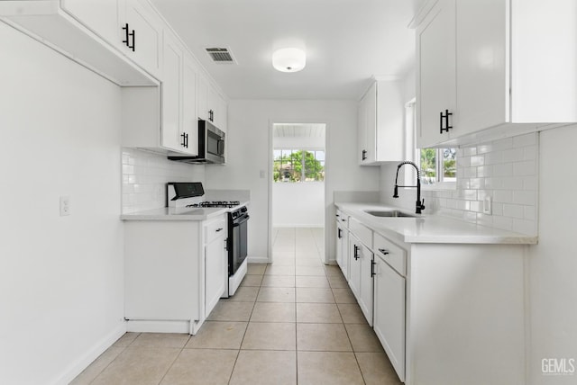 2804 Haley St, Bakersfield, CA 93305 - kitchen featuring range with gas stovetop, a sink, decorative backsplash, baseboards, and stainless steel microwave