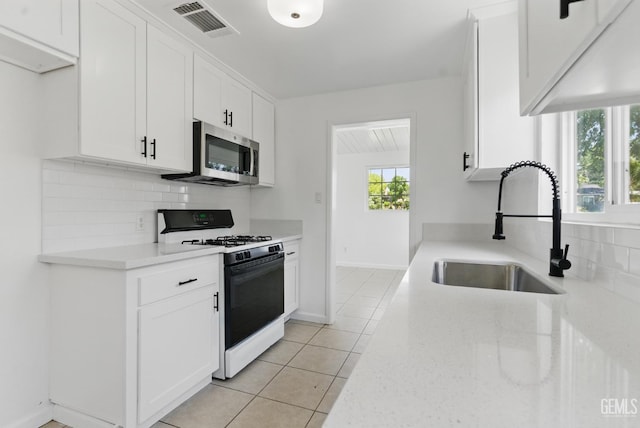 2804 Haley St, Bakersfield, CA 93305 - kitchen with gas stove, stainless steel microwave, a sink, tasteful backsplash, and white cabinets