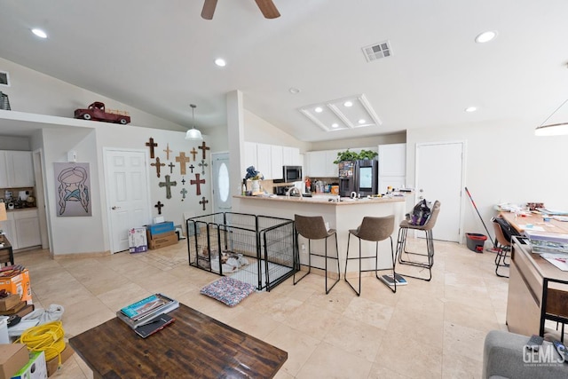 7519 Shadow Wells St, Bakersfield, CA 93313 - kitchen with stainless steel appliances, a kitchen bar, vaulted ceiling, a peninsula, and white cabinets