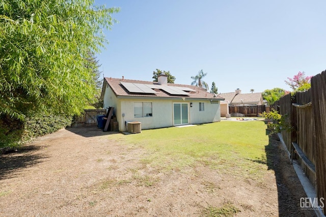 7519 Shadow Wells St, Bakersfield, CA 93313 - back of property featuring stucco siding, roof mounted solar panels, and a fenced backyard