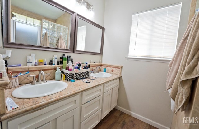 7519 Shadow Wells St, Bakersfield, CA 93313 - full bathroom with double vanity, wood finished floors, and healthy amount of natural light
