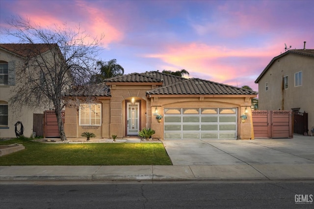 mediterranean / spanish home with concrete driveway, a tiled roof, an attached garage, and stucco siding