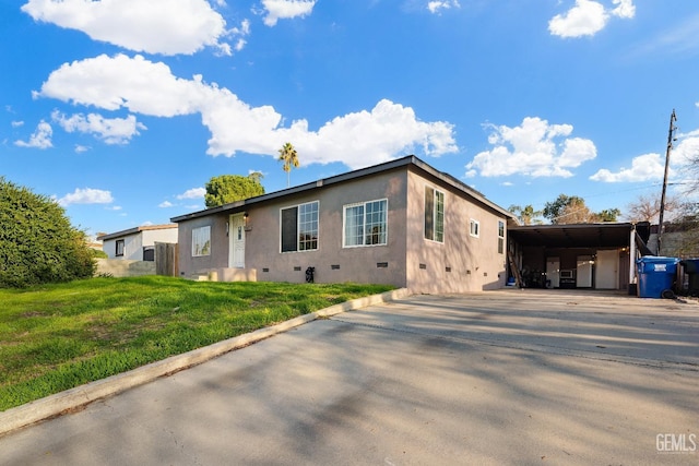 view of front facade featuring a carport and a front yard