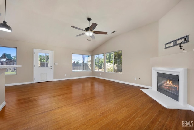10318 Roehampton Ave, Bakersfield, CA 93312 - unfurnished living room with wood finished floors, ceiling fan, vaulted ceiling, and a glass covered fireplace