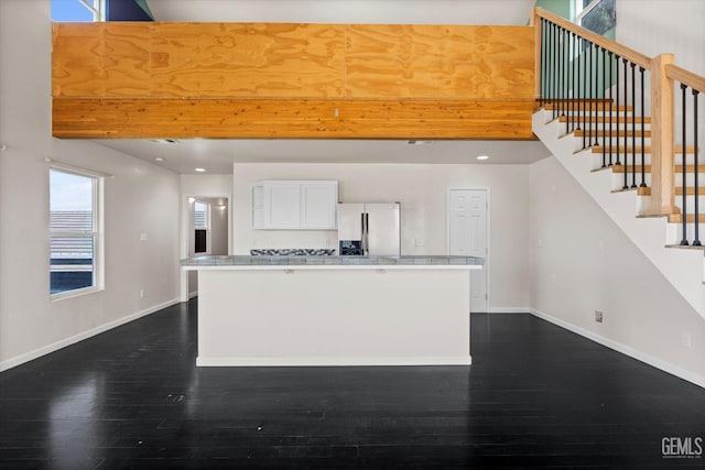 10318 Roehampton Ave, Bakersfield, CA 93312 - kitchen with refrigerator with ice dispenser, dark wood-style flooring, white cabinetry, a kitchen island, and light countertops