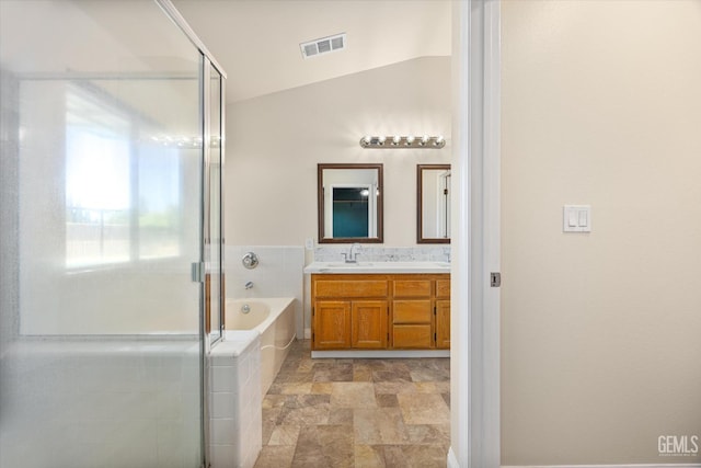 10318 Roehampton Ave, Bakersfield, CA 93312 - bathroom with double vanity, a bath, a stall shower, stone finish flooring, and vaulted ceiling