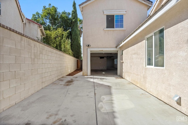 10318 Roehampton Ave, Bakersfield, CA 93312 - view of side of property with stucco siding, a fenced backyard, concrete driveway, an attached garage, and a patio