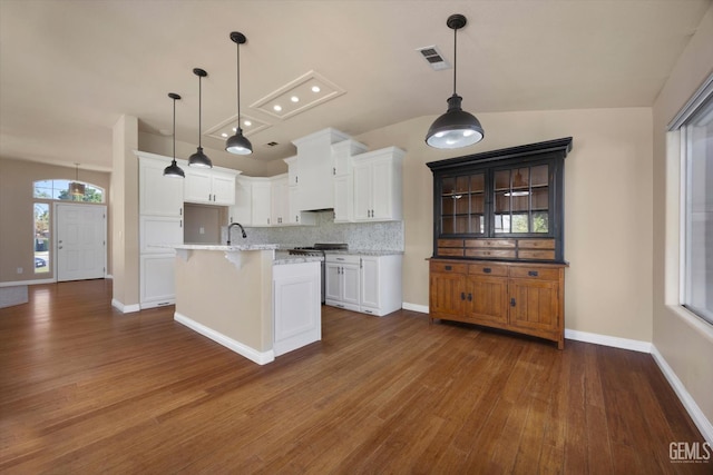 10318 Roehampton Ave, Bakersfield, CA 93312 - kitchen featuring dark wood-style flooring, backsplash, white cabinets, a center island with sink, and a kitchen breakfast bar