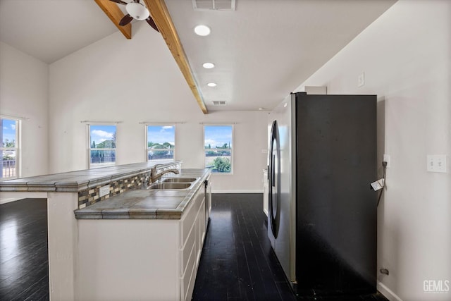 10318 Roehampton Ave, Bakersfield, CA 93312 - kitchen featuring freestanding refrigerator, white cabinets, tile countertops, dark wood finished floors, and healthy amount of natural light