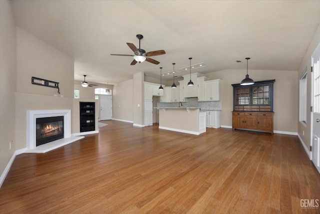 10318 Roehampton Ave, Bakersfield, CA 93312 - unfurnished living room with ceiling fan, vaulted ceiling, light wood finished floors, and a glass covered fireplace