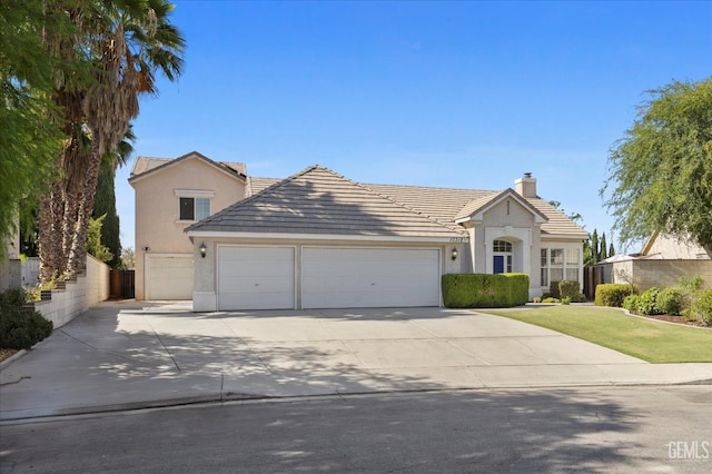 10318 Roehampton Ave, Bakersfield, CA 93312 - view of front facade with an attached garage, stucco siding, driveway, a tiled roof, and a chimney