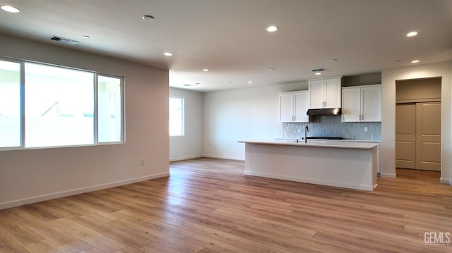 12801 Kinnick Ct, Bakersfield, CA 93311 - kitchen with backsplash, open floor plan, light wood-type flooring, recessed lighting, and white cabinets