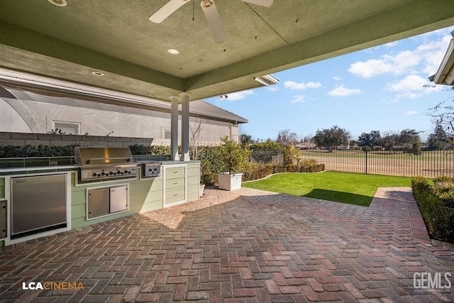 view of patio with ceiling fan, an outdoor kitchen, and grilling area