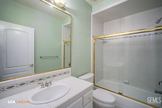 full bathroom with vanity, toilet, and combined bath / shower with glass door