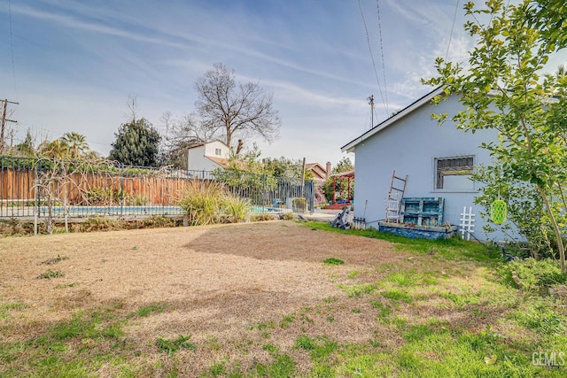 view of yard with a pool and fence