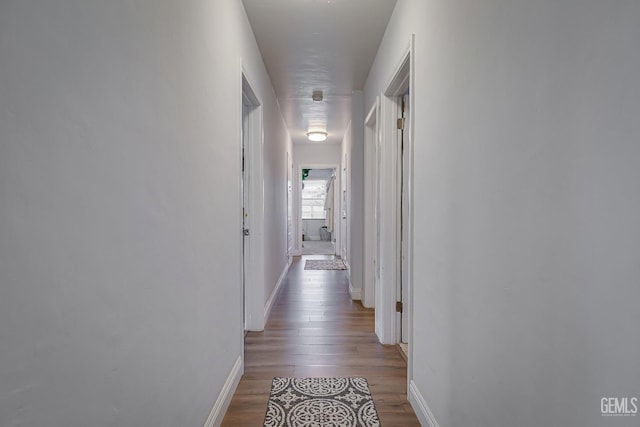 hall featuring baseboards and wood finished floors