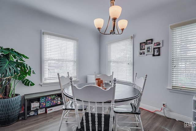 dining area featuring baseboards, a notable chandelier, and wood finished floors