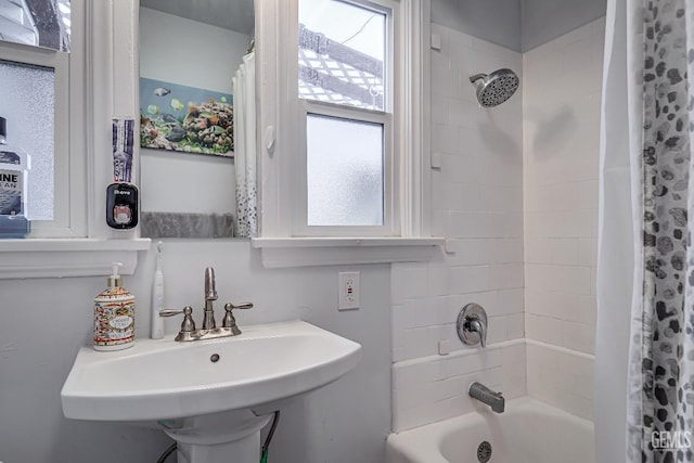 bathroom featuring a sink and shower / tub combo with curtain