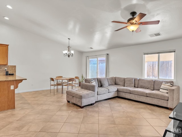 living room featuring visible vents, light tile patterned floors, ceiling fan with notable chandelier, and lofted ceiling