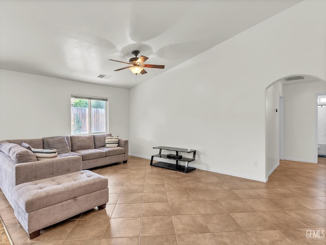 living area featuring visible vents, arched walkways, a ceiling fan, and light tile patterned flooring