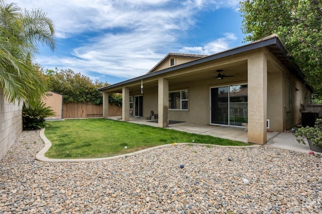 9310 Via Catania, Bakersfield, CA 93312 - back of property featuring fence, ceiling fan, stucco siding, and a lawn