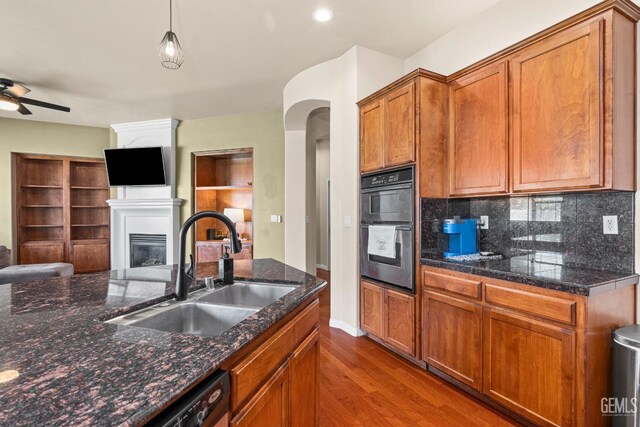 9310 Via Catania, Bakersfield, CA 93312 - kitchen featuring a sink, a glass covered fireplace, open floor plan, backsplash, and wood finished floors