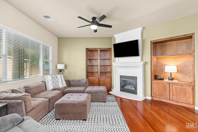 9310 Via Catania, Bakersfield, CA 93312 - living room featuring visible vents, ceiling fan, wood finished floors, and a glass covered fireplace