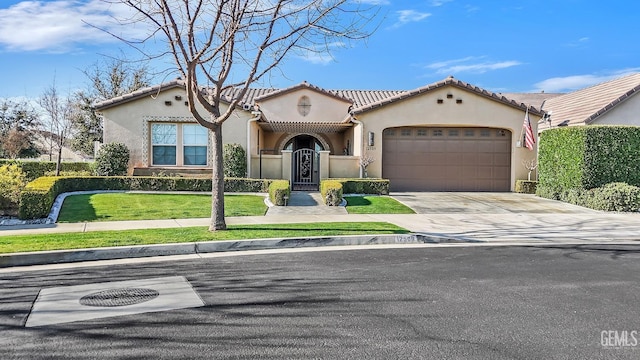 mediterranean / spanish home with a garage and a front lawn