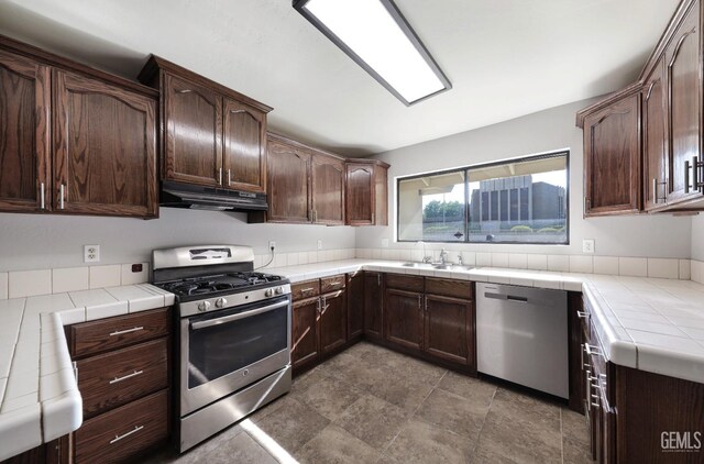2800 S Real Rd, Bakersfield, CA 93309 - kitchen featuring appliances with stainless steel finishes, tile countertops, under cabinet range hood, and dark brown cabinets