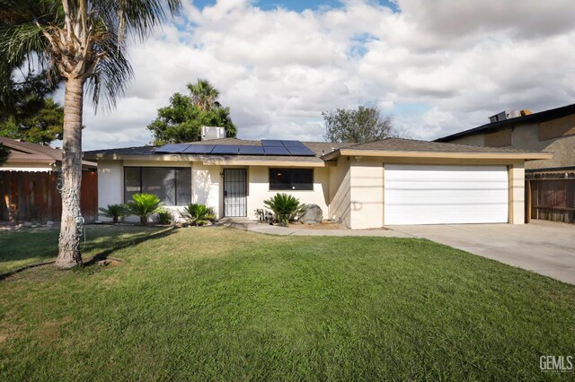 2800 S Real Rd, Bakersfield, CA 93309 - view of front of property featuring an attached garage, roof mounted solar panels, stucco siding, and driveway