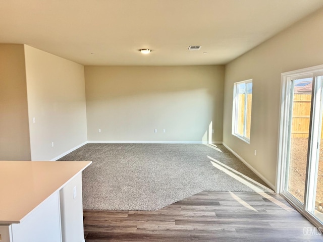 empty room with hardwood / wood-style floors and a healthy amount of sunlight