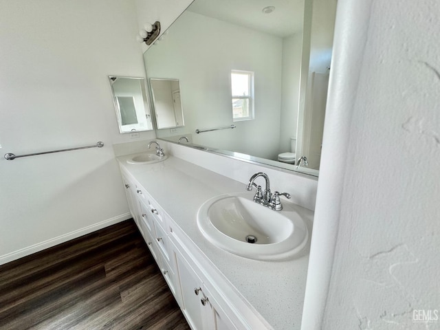 bathroom with hardwood / wood-style floors, vanity, and toilet