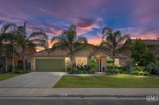 view of front facade featuring a front lawn, driveway, an attached garage, and stucco siding