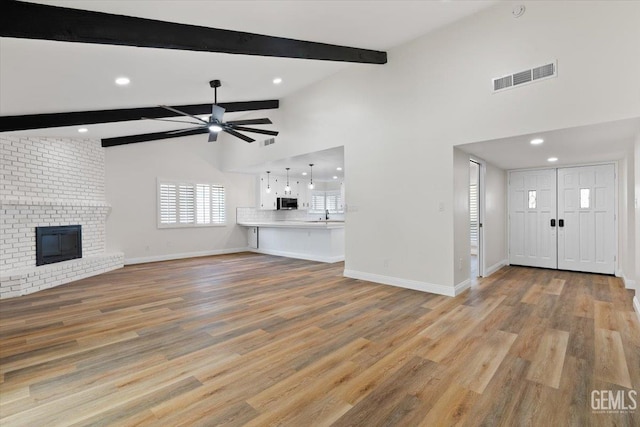 5100 Ruth Ct, Bakersfield, CA 93308 - unfurnished living room with a ceiling fan, beam ceiling, light wood-type flooring, recessed lighting, and a fireplace