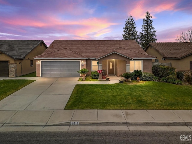 view of front of house with a garage and a yard