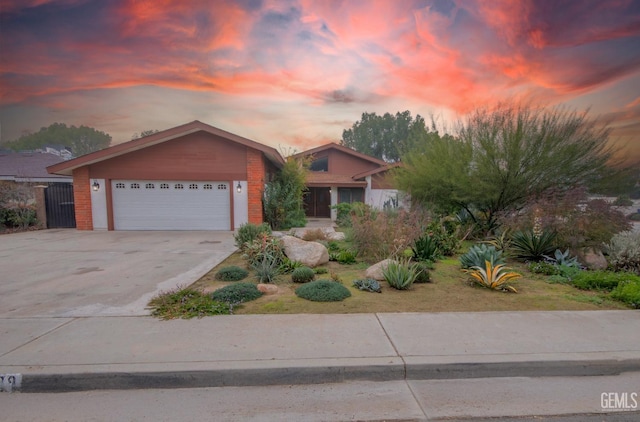 view of front of property with a garage, driveway, and brick siding