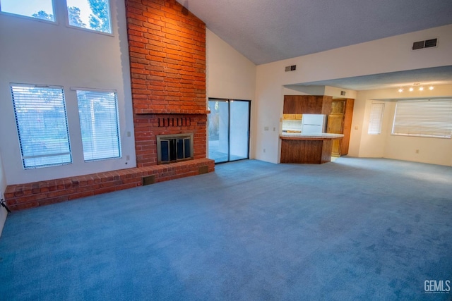 unfurnished living room with high vaulted ceiling, carpet, a brick fireplace, and visible vents