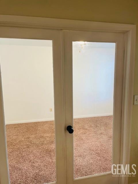 corridor featuring baseboards and carpet floors