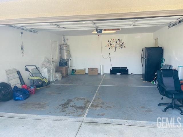 garage featuring freestanding refrigerator, secured water heater, and a garage door opener