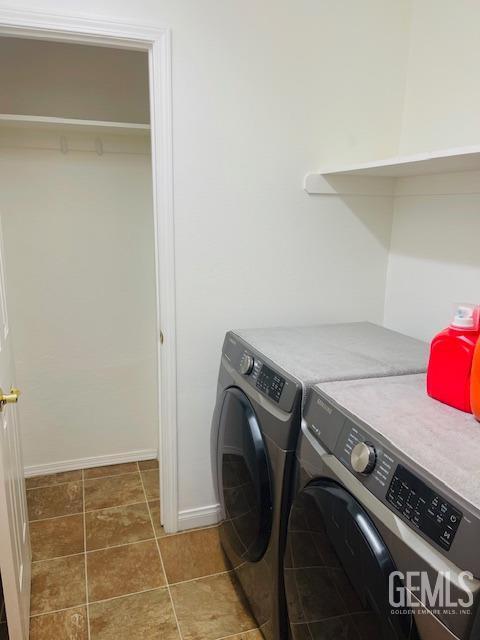 laundry room featuring washing machine and clothes dryer, baseboards, and laundry area