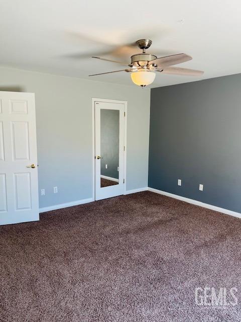 empty room featuring baseboards, carpet flooring, and ceiling fan