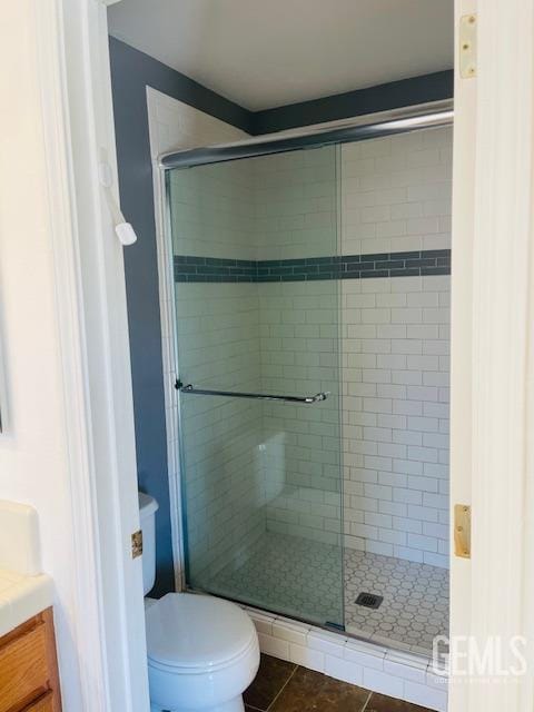 full bath featuring a shower stall, tile patterned flooring, vanity, and toilet