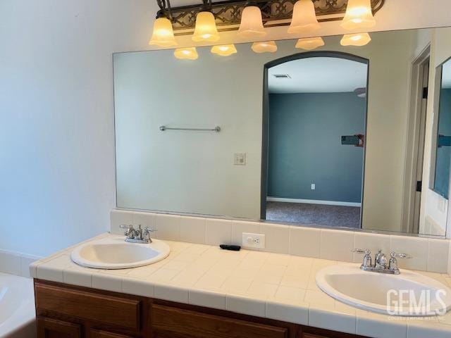full bathroom with a tub to relax in, a sink, and double vanity