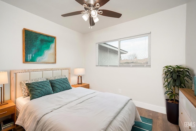 bedroom featuring a ceiling fan, baseboards, and wood finished floors