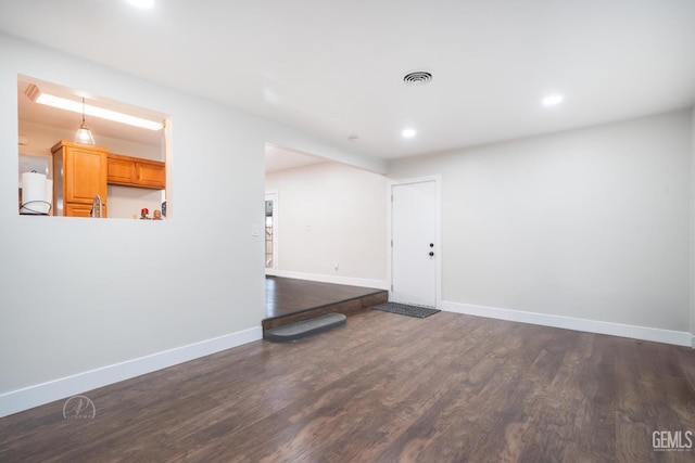 spare room with dark wood-style floors, recessed lighting, visible vents, and baseboards